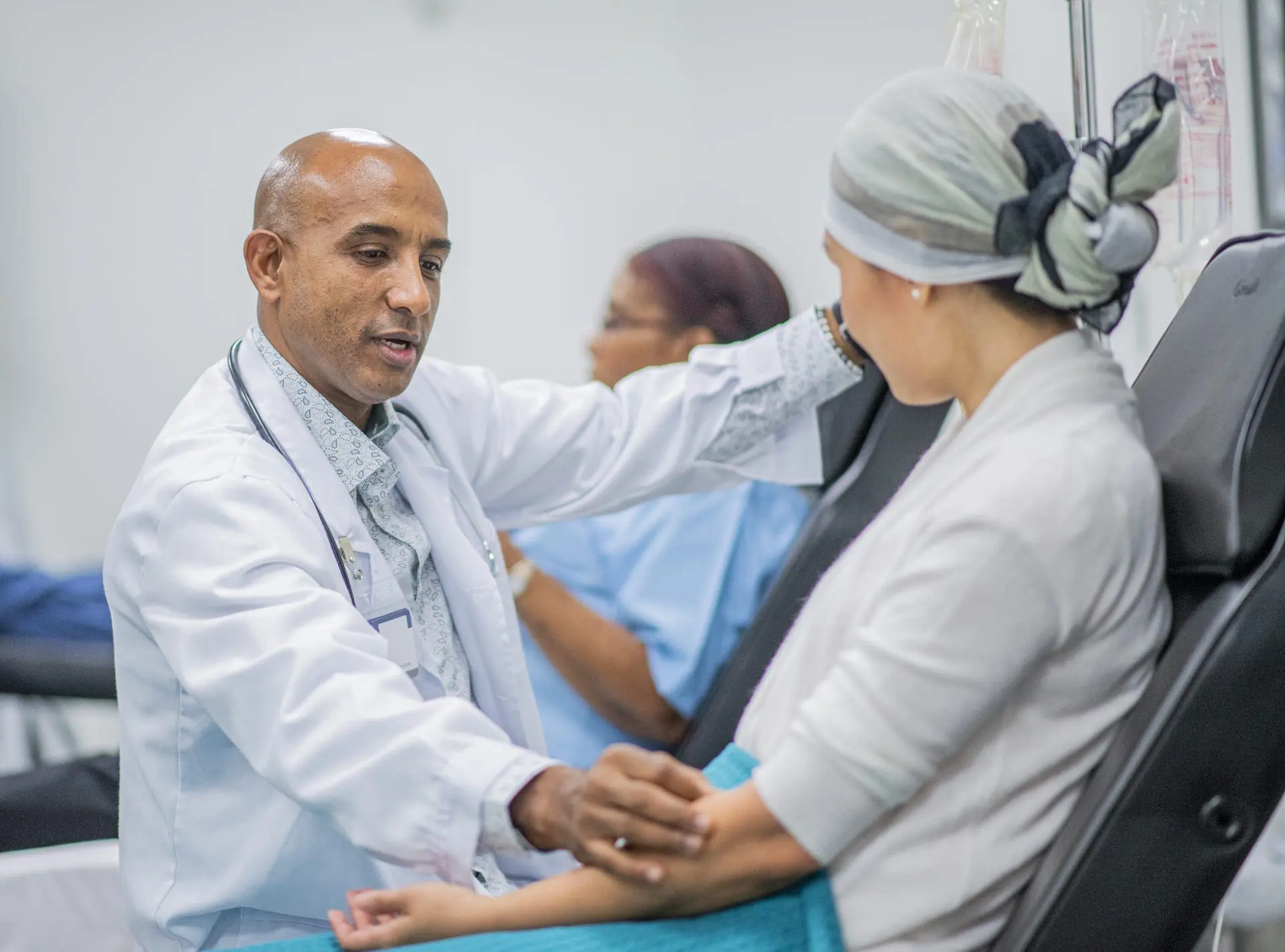 Doctor giving IV drip treatment to cancer patient